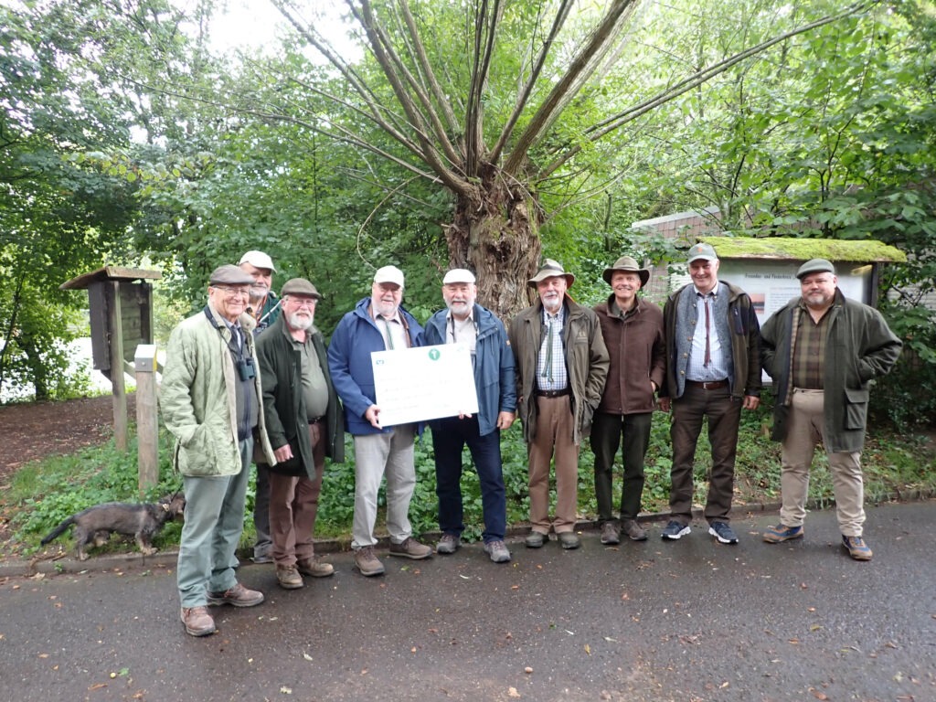 Symbolische Checkübergabe durch Ordensbrüder aus dem Breich West der Landesgruppe Deutschland im Orden "Der silberne Bruch" an einen Mitarbeiter der Biologischen Station Rieselfelder Münster. Von L nach R: K. Gunter von Kajdacsy, Matthias Kruse, Heiner Nitsch, Ludwig Steinberg (Bereichsleiter West), H.-U. Schütz (Biolog. Station), Erich Schmidt, Jürgen Cramer, Jörg Patzwald, Sven Stemmer.
